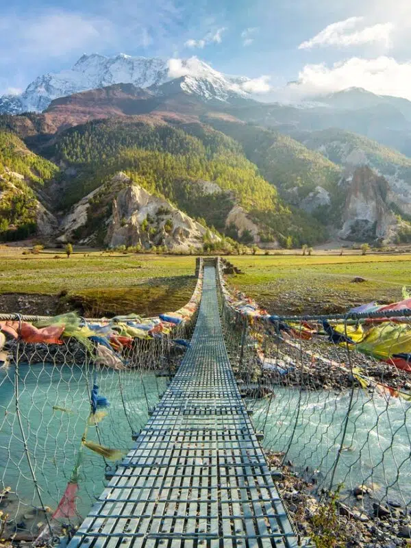 A suspension bridge over a river in the mountains of Nepal on a school expedition