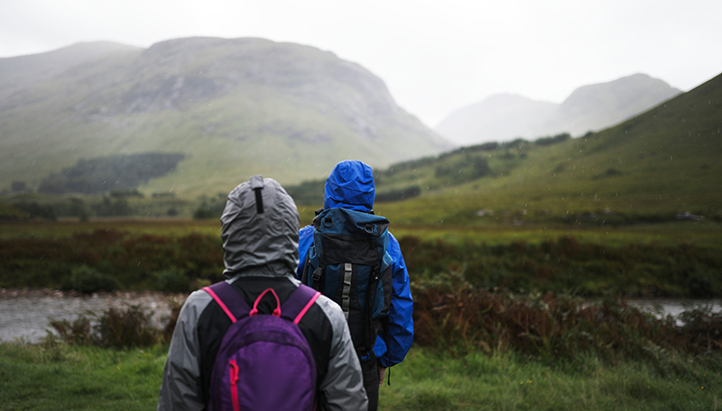 Students on an expedition in heavy rain, showcasing adaptability and teamwork