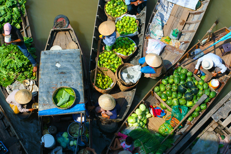 Helping local food vendors on their boats on the river on a school expedition