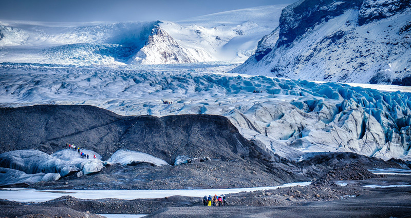 School groups exploring a glacier on a geography field trip